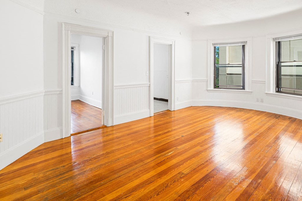 an empty living room with wood floors and windows