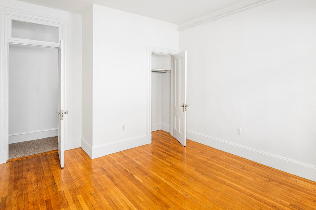 a room with wood floors and white walls and doors