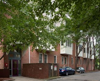 a row of apartment buildings with cars parked in front of them