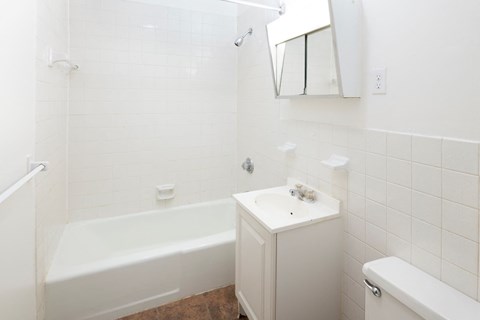 a white bathroom with a sink and a bath tub