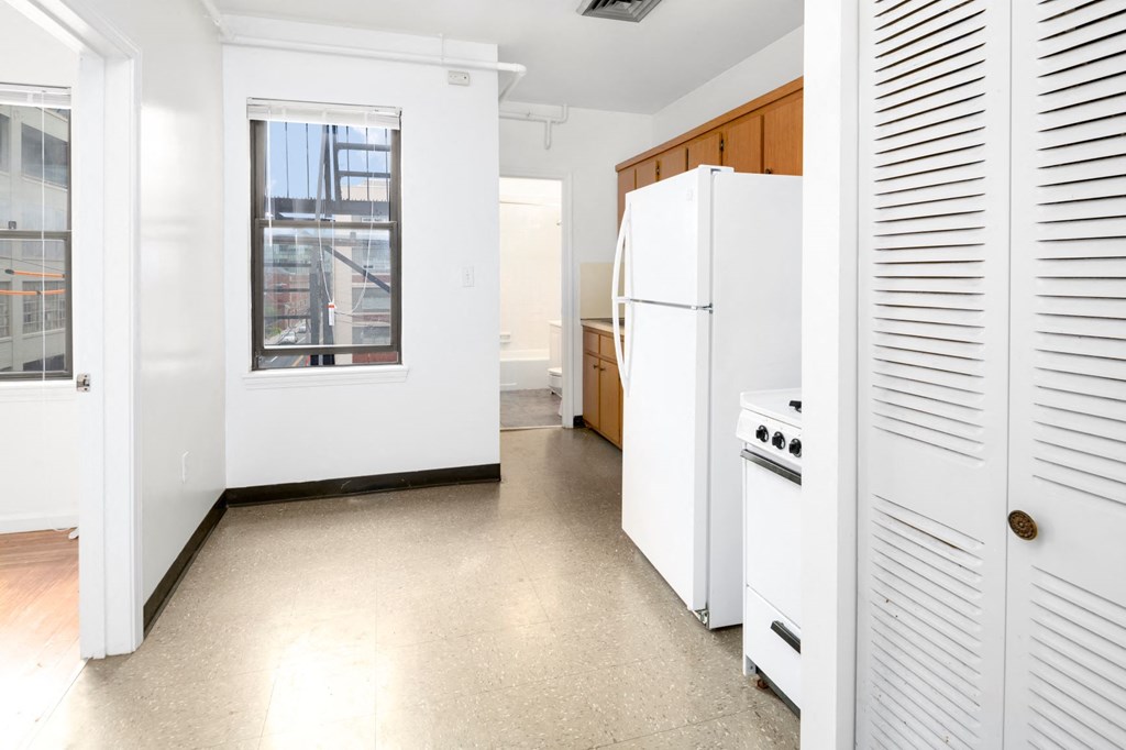 a kitchen with a white refrigerator and a window