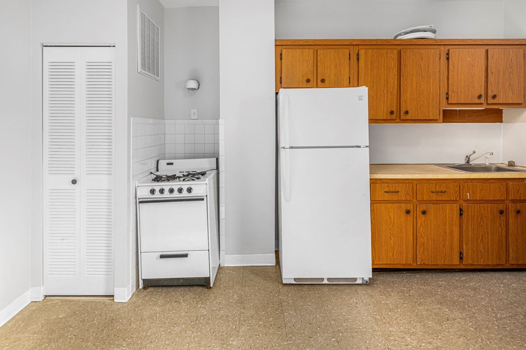 a kitchen with a stove refrigerator and sink