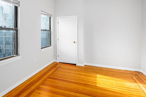 a living room with wood floors and a white door