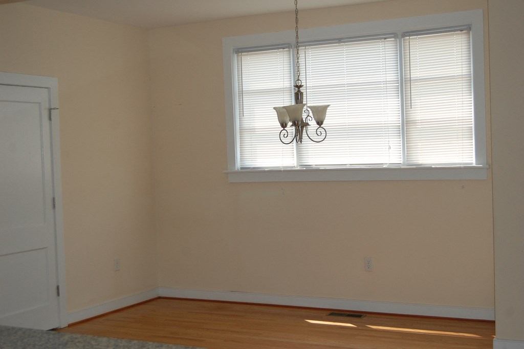 an empty room with a window and a chandelier