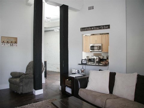 a living room with a couch and a kitchen