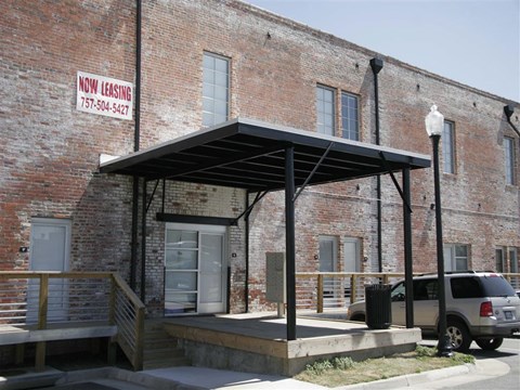 an old brick building with awning and a car parked outside