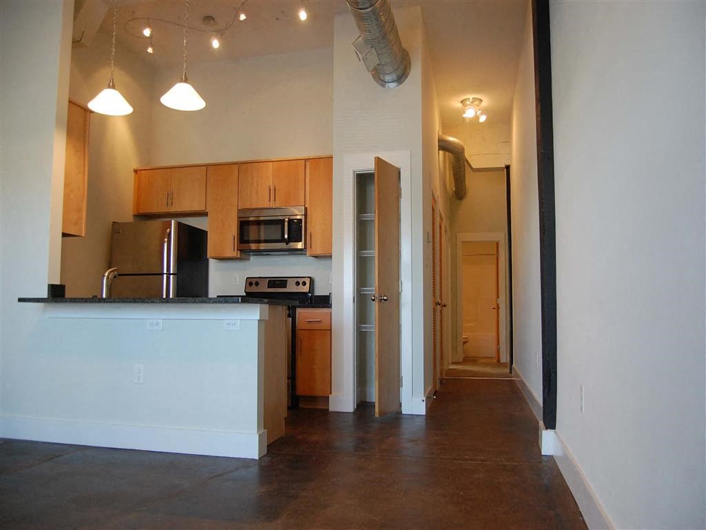 an empty kitchen with a counter and a refrigerator