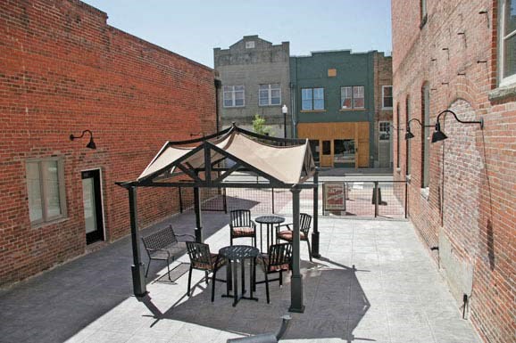 a patio with tables and chairs and a tent