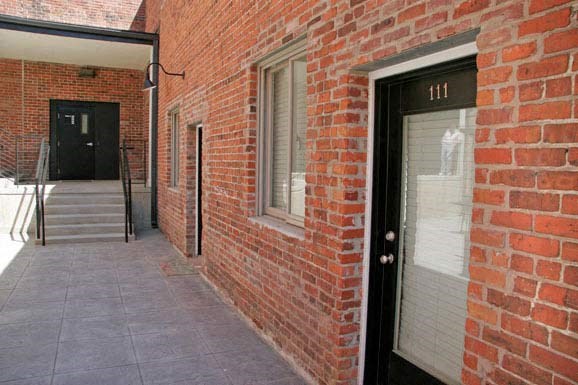 a red brick building with a black door and stairs