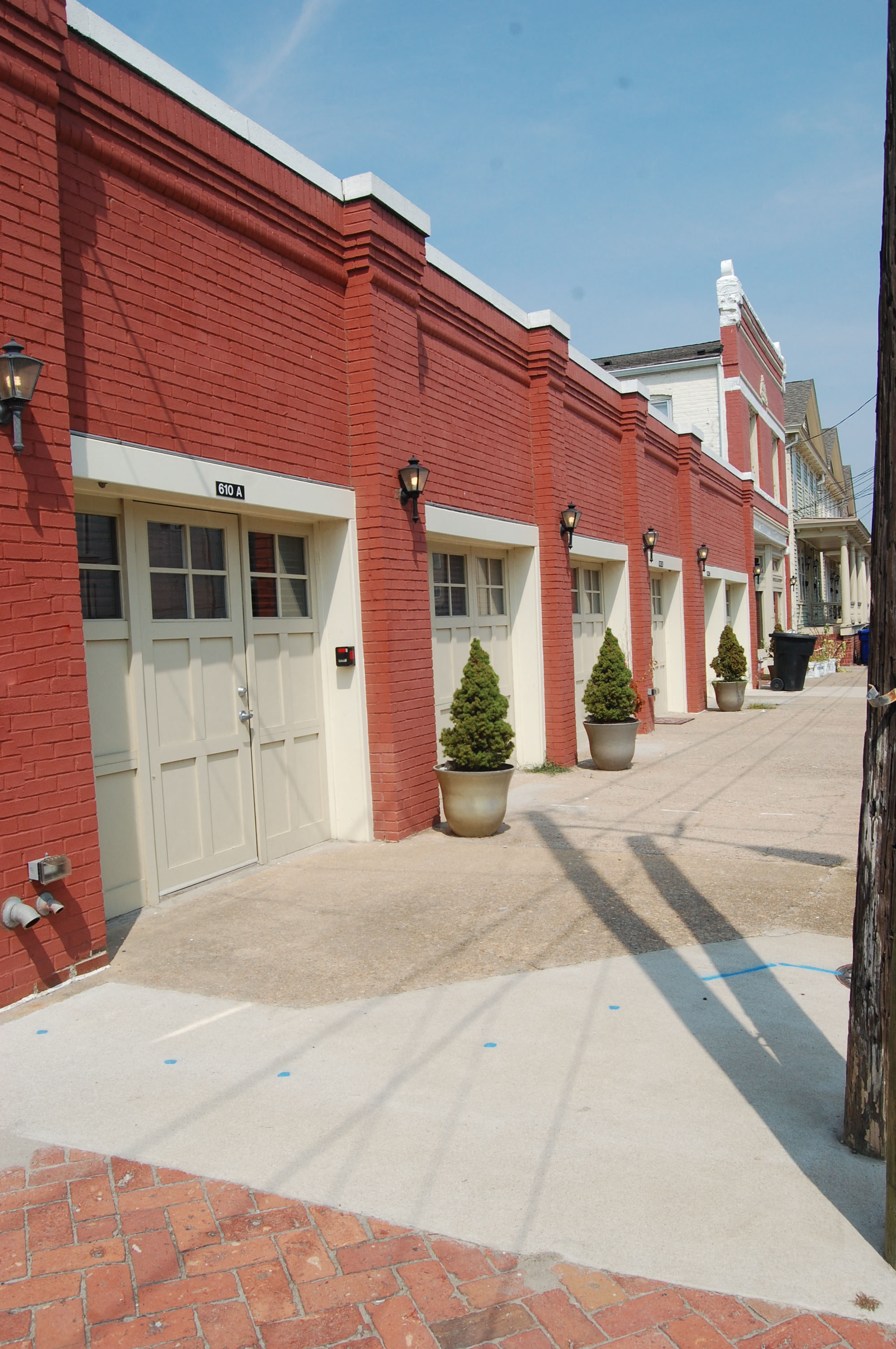 the side of a red brick building with white garage doors
