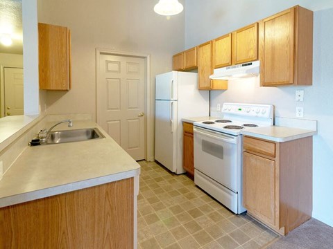 a kitchen with white appliances and wooden cabinets