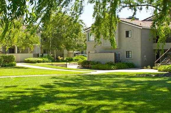 an apartment building with green grass and trees