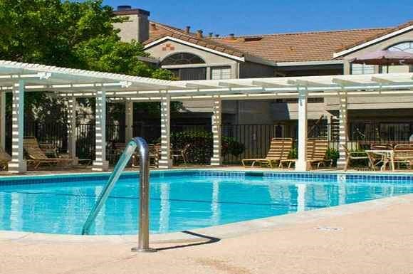 a swimming pool with a patio next to a hotel