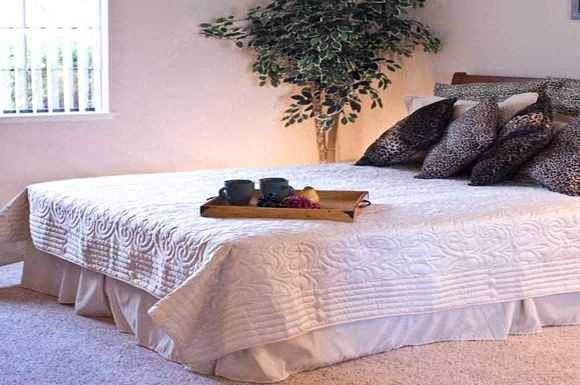 a bed with a white comforter and pillows on it