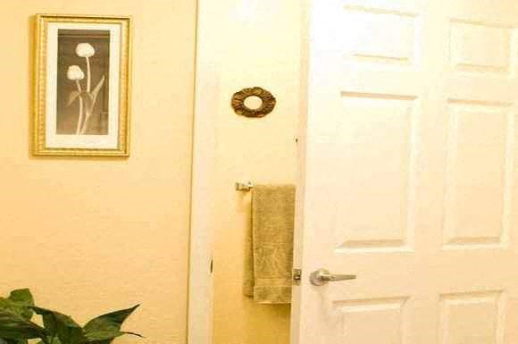 a bathroom with a white door and a towel hanging on the wall