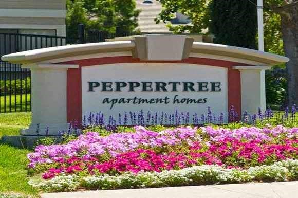 a sign forpperree apartment homes in front of a yard of flowers
