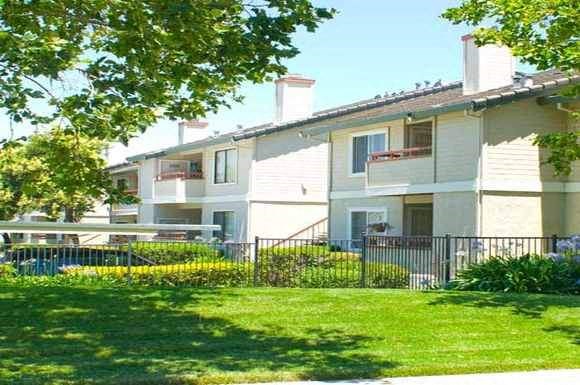 an apartment building with a yard and grass
