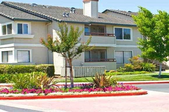 a white house with a bench in front of a garden