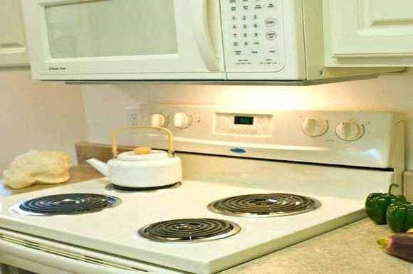 a white stove with a tea kettle on top of it