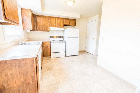 a kitchen with white appliances and wooden cabinets