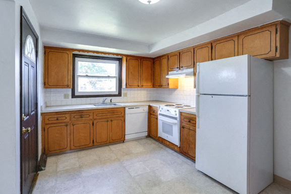 a kitchen with white appliances and wooden cabinets