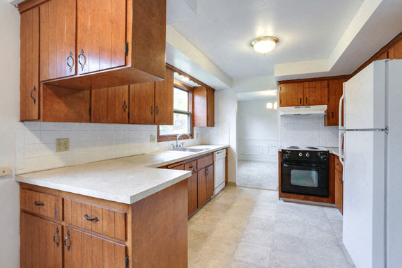 a kitchen with wooden cabinets and a stove and a refrigerator