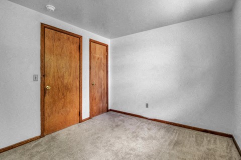 a bedroom with white walls and a wooden door