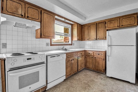 a kitchen with white appliances and wooden cabinets