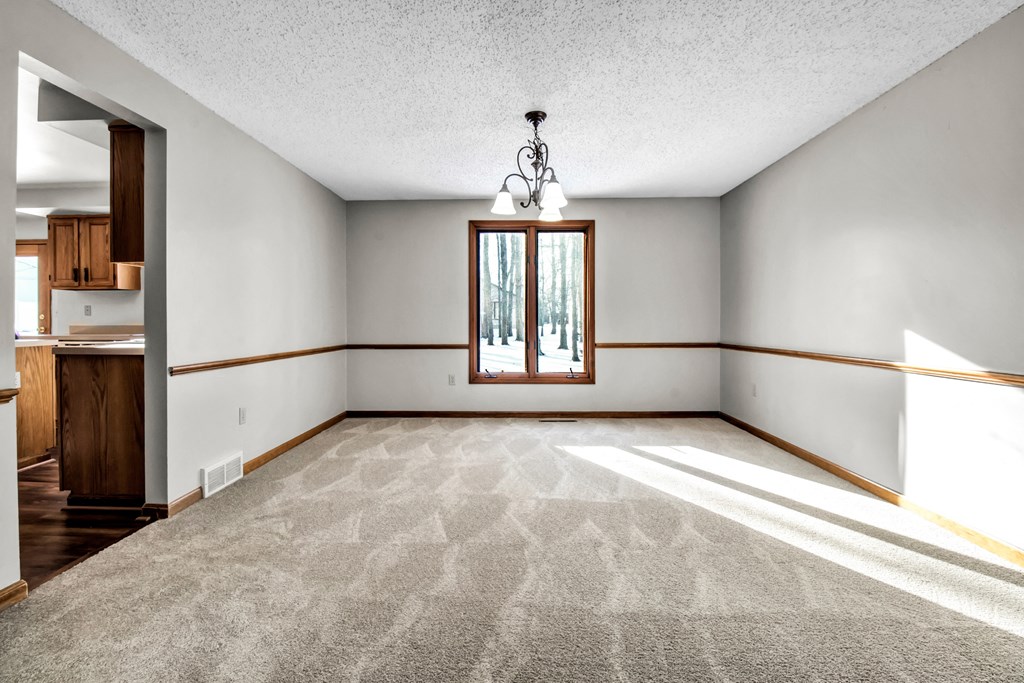 an empty living room with white walls and a window