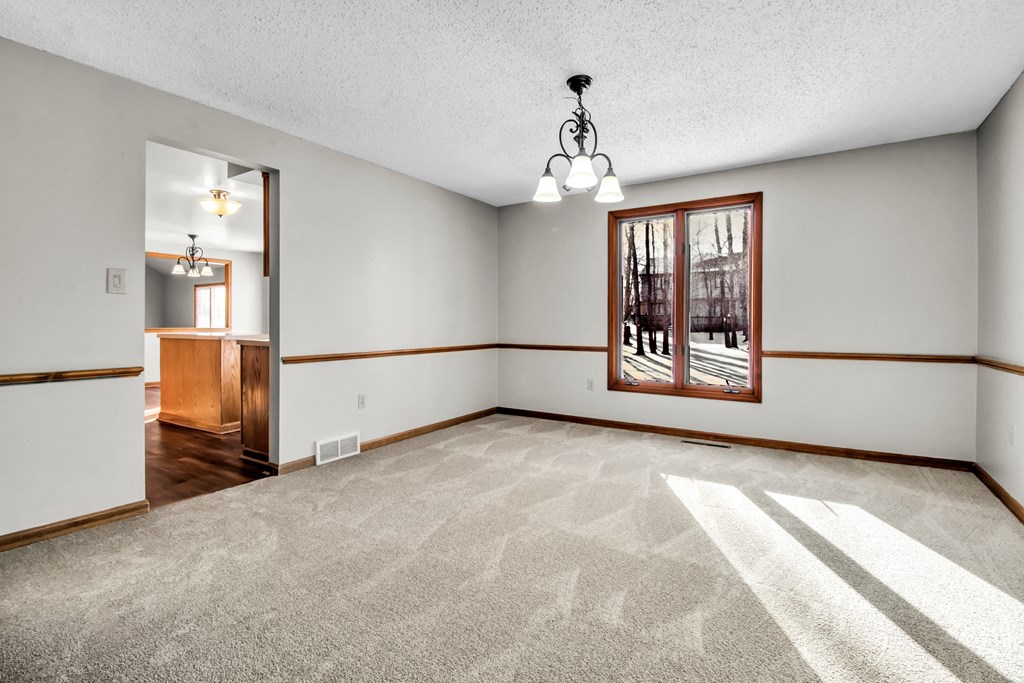 an empty living room with white walls and a window
