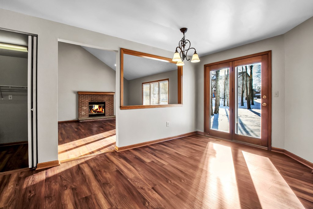 an empty living room with a fireplace and a glass door