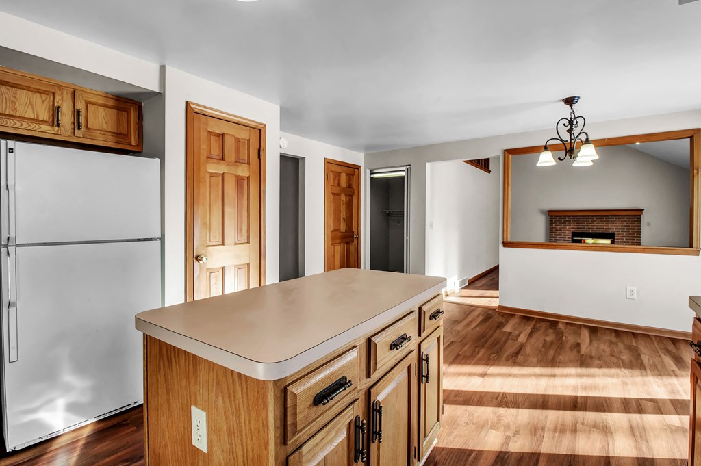 a kitchen with an island and a living room with a fireplace