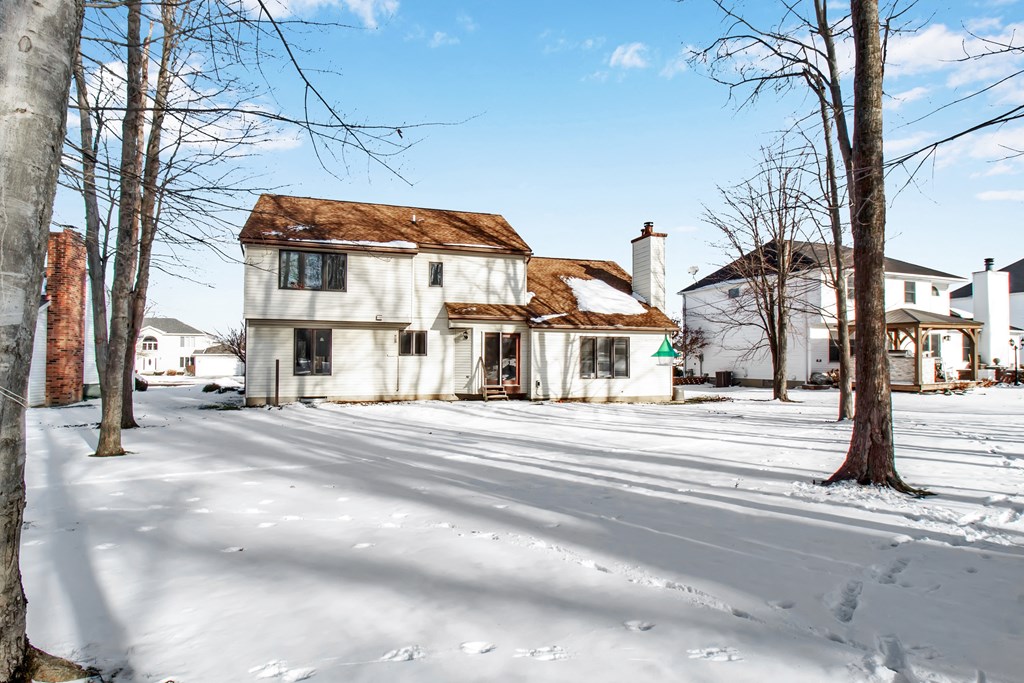 a white house with a brown roof in the snow