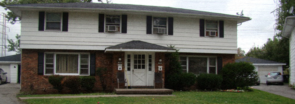 A white house with a black roof and a white door.