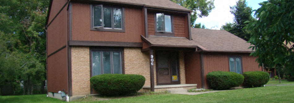 A brown house with a white door and windows.