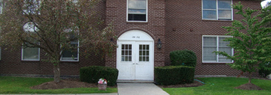 a white door in front of a brick building