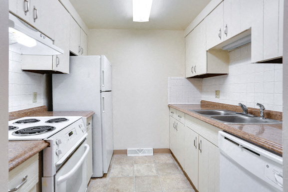 A kitchen with white appliances and cabinets.