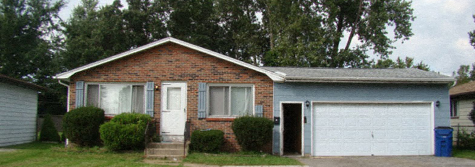 A small house with a white door and a white garage door.