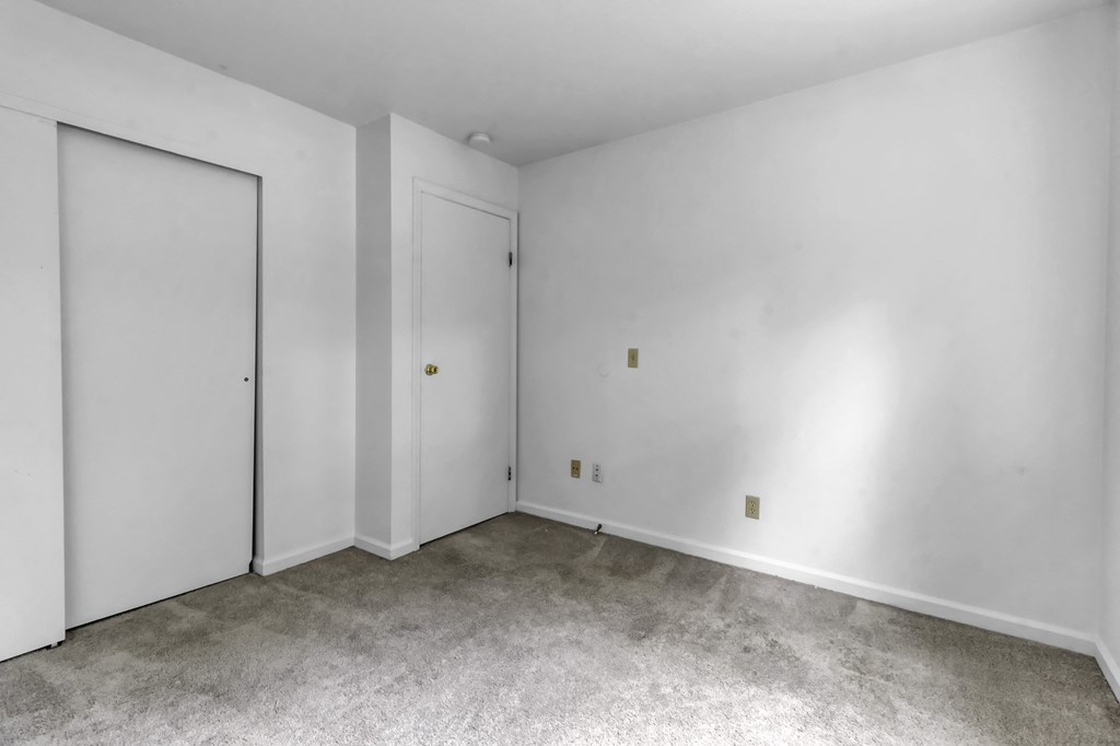 an empty room with white walls and white doors