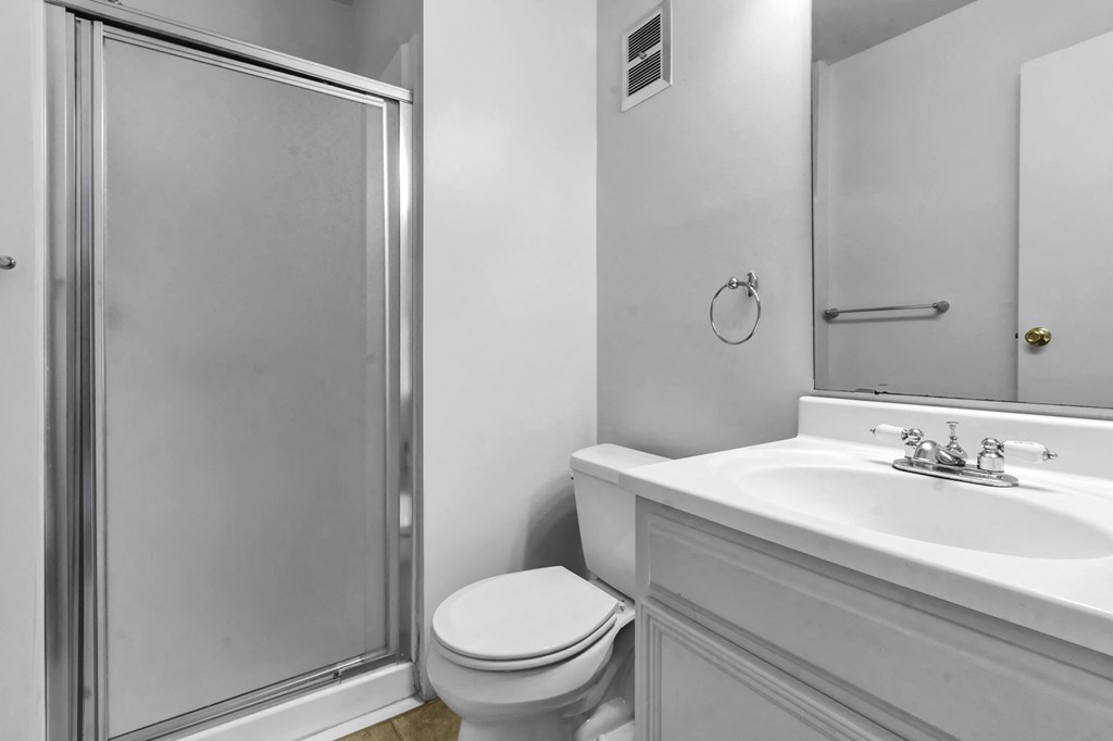a bathroom with a shower and a sink and a toilet