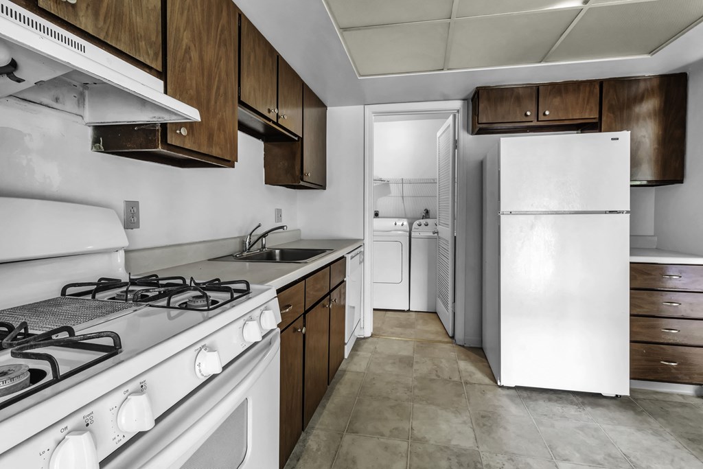a kitchen with white appliances and wooden cabinets and a white refrigerator
