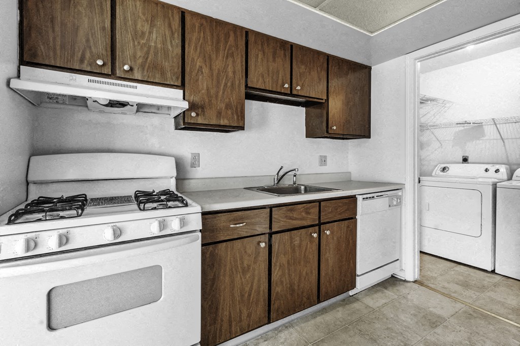 a kitchen with white appliances and wooden cabinets