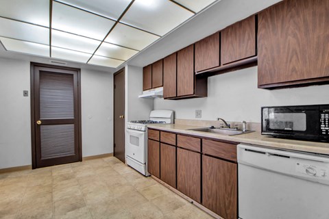A kitchen with brown cabinets and white appliances.