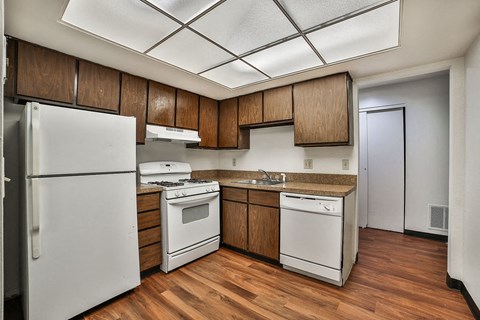 a kitchen with white appliances and wooden cabinets