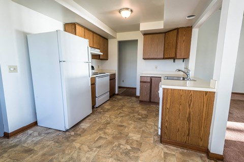 a kitchen with white appliances and wooden cabinets and a white refrigerator