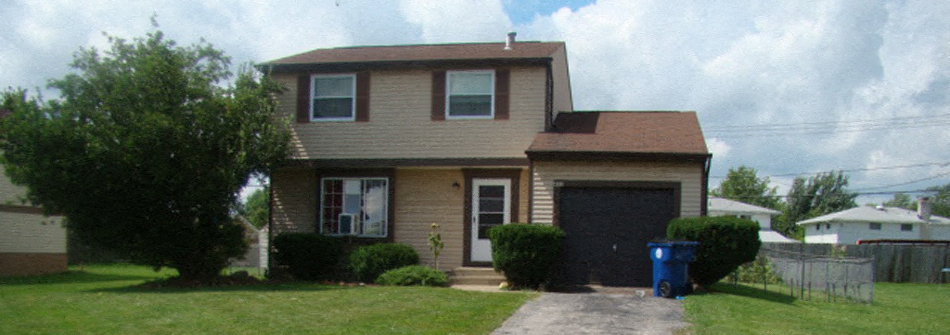 A house with a brown roof and a black garage door.