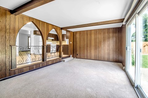 a living room with a carpeted floor and a balcony