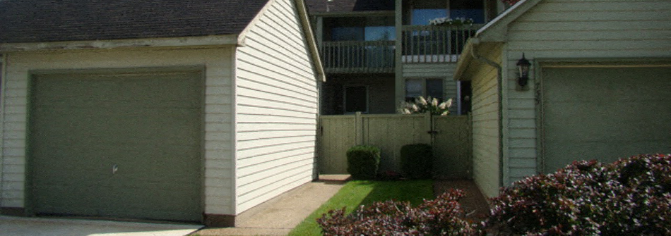 A white house with a green garage door.