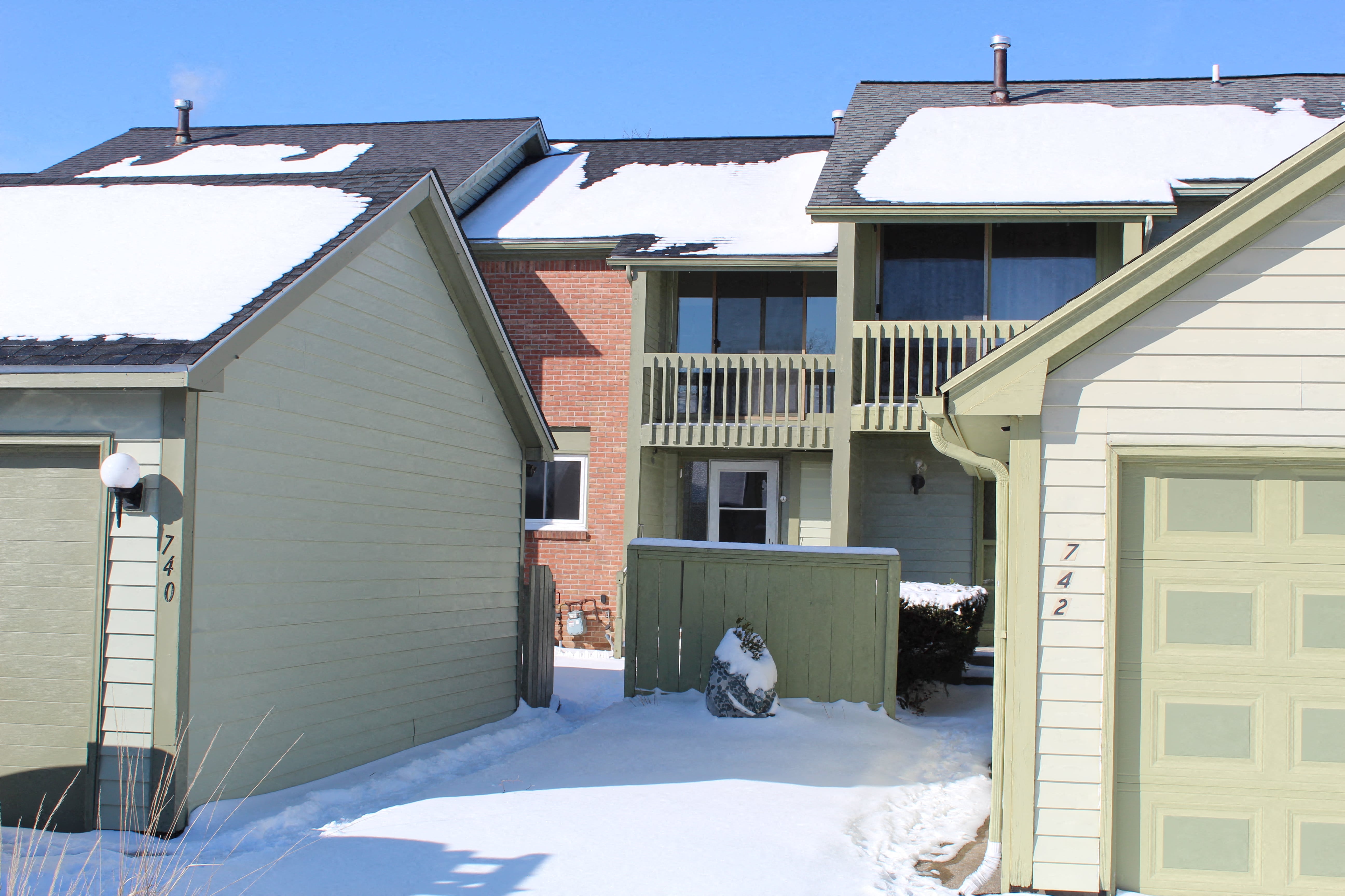 A house with a garage and a snow-covered ground.
