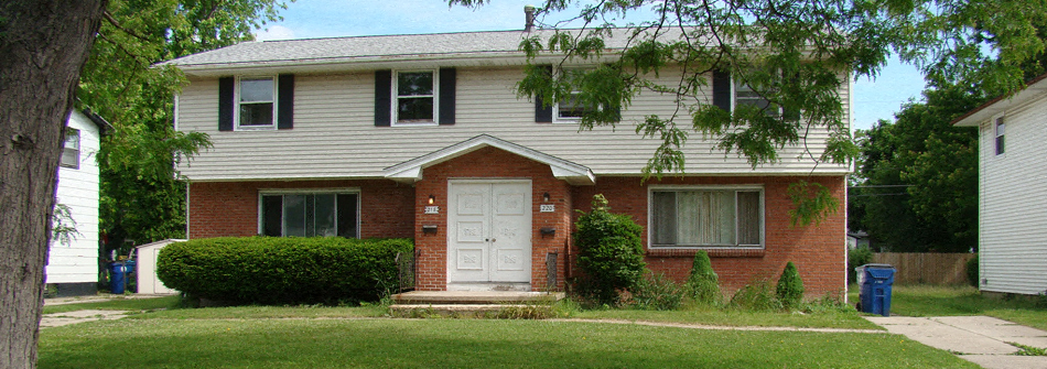 A house with a white door and a small front yard.